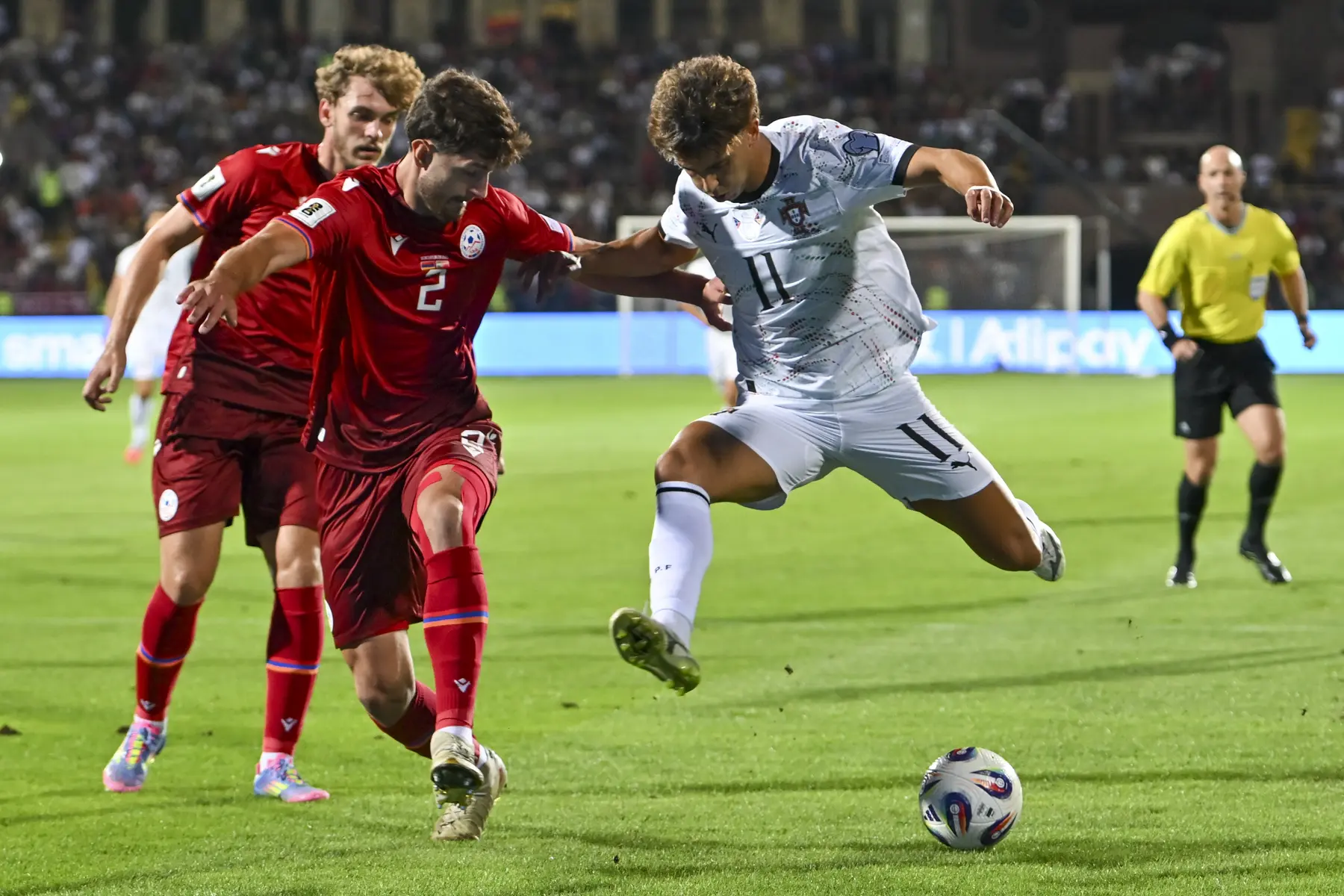 João Félix, com a equipa de Portugal, disputa a bola com um jogador adversário durante um jogo.